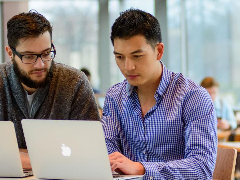 Two students looking at a laptop screen.